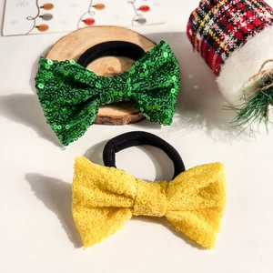 Détail de chouchous à nœuds pailletés jaune et vert pour coiffures de Noël