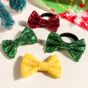 Détail de nœuds papillon à paillettes pour cheveux aux couleurs festives de Noël rouge et vert