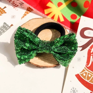 Détail d'un chouchou noeud à paillettes vertes de Noël sur plateau bois