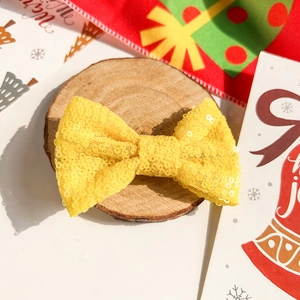 Détail d'un nœud papillon à paillettes jaunes scintillantes pour accessoire de Noël