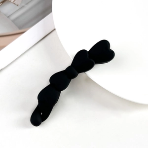 Dettaglio macro di un fermaglio per capelli nero opaco con design a forma di cuore mini