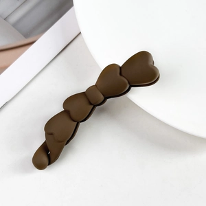 Dettaglio della molletta per capelli marrone opaco con cuori e finitura satinata