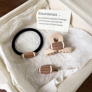 Vue détaillée du set d'accessoires rugby avec charmes football en résine et barrettes