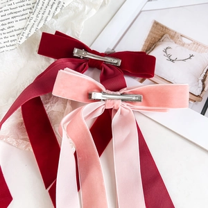Vue détaillée des pinces à cheveux en velours bordeaux et rose avec clips métalliques