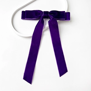 Detail of high-quality purple velvet bow hair clip with elegant long hanging ribbons