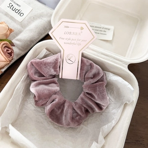 Detailed view of mauve velvet hair scrunchie with soft texture and elegant packaging