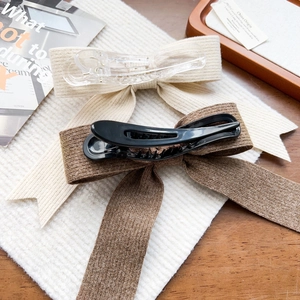 Détail de barrettes nœuds en tricot beige et marron avec texture côtelée