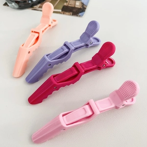 Detail view of 4 professional matte hair clips in apricot, purple, magenta, and pink colors