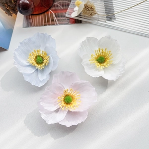 Détail de trois pinces à cheveux pavot artificielles en bleu, blanc et rose en soie