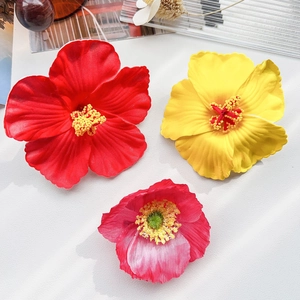 Vue détaillée de pinces à fleurs d'hibiscus artificielles en couleurs rouge et jaune