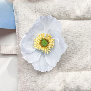 Détail macro d'une pince fleur en soie dégradé bleu avec des étamines jaunes fines