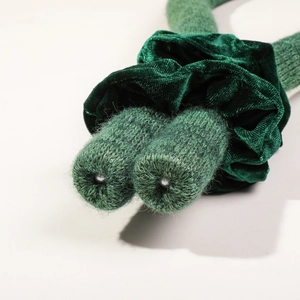 Vue détaillée de la texture du velours vert et du tricot avec perle en métal argenté