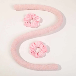 Ensemble détaillé de bigoudis sans chaleur roses avec deux chouchous en velours sur fond blanc