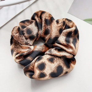 Close-up of leopard print satin scrunchie with soft silk texture and elastic inner band