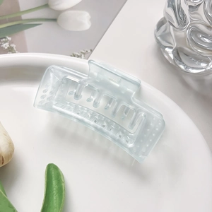 Détail d'une pince à cheveux bleue givrée avec dents creuses et mécanisme à ressort robuste