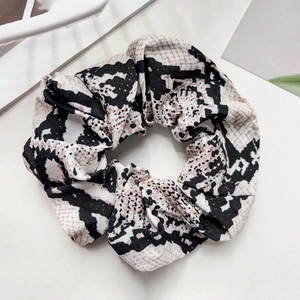 Close-up of leopard print fabric scrunchie with elastic detail and rich texture