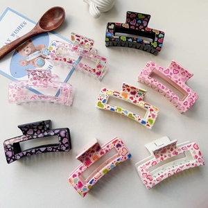 Detailed flat lay of eight acrylic heart-patterned hair claws in assorted pastel colors