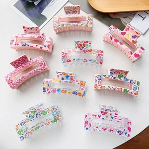 Flat lay of colorful heart pattern square shark hair claws in various vibrant designs