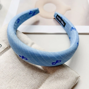Macro shot of blue padded headband fabric with butterfly pattern and handmade label