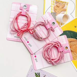Détail d'élastiques à cheveux roses avec nœuds et perles sur une carte mini girl élégante