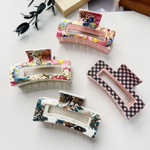 Detail showing four assorted floral and plaid pattern large square hair claws for women