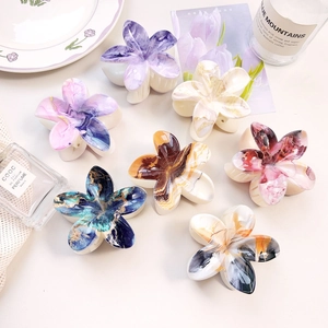 Detail view of colorful UV printed floral hair claws with elegant marble texture patterns