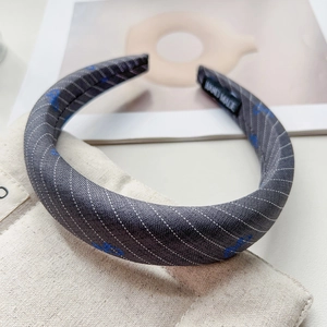 Detail view of handmade grey fabric headband featuring blue patterns and stripe texture