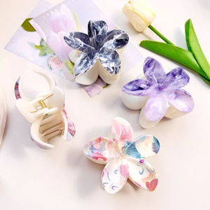 Detail view of 4-piece marble floral hair clips set with sturdy gold metal springs