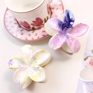 Detail of marble pattern and floral print flower hair claws on a marble surface