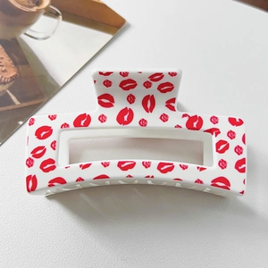 Detail view of white heart hair claw clip with red lip and rose floral prints