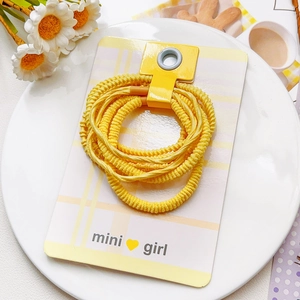 Lot de chouchous jaunes haute élasticité sur carte mini girl dans un plateau blanc