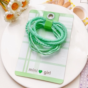 Détail d'élastiques à cheveux côtelés vert menthe sur carte décorative mini girl