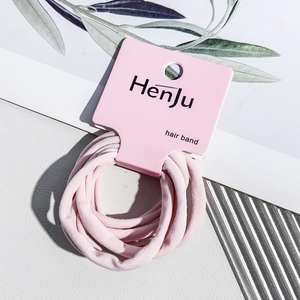Close-up of pink elastic hair bands set on a minimalist paper card holder