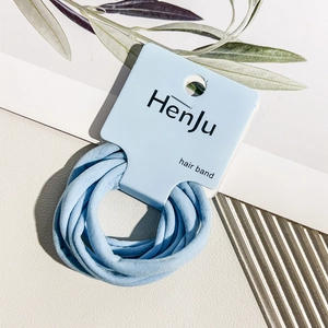 Detail of light blue high-elastic hair bands on a display card with a soft fabric texture