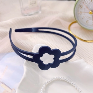 Détail du serre-tête bleu marine à fleurs avec double rangée sur plateau coquillage