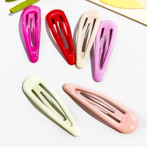Detailed view of colorful teardrop metal snap clips with smooth glossy finish