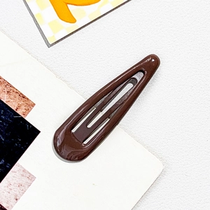 Detailed close-up of a chocolate brown teardrop metal snap hair clip with glossy finish