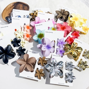 Detailed view of floral claw hair clips in assorted colors on a display card