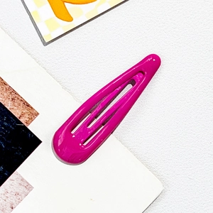 Detail of rose red drop-shaped metal BB clip with glossy finish on textured background