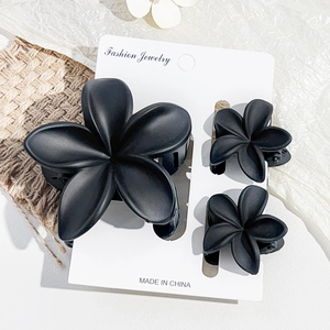 Set of three matte black flower hair claws in different sizes for elegant beach styling