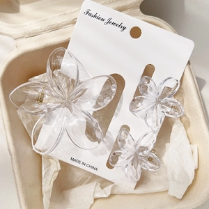 Detail view of large and small plumeria hair claws on display cards in eco packaging
