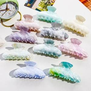 Flat lay of colorful marble textured hair claws in various pastel acetate finishes