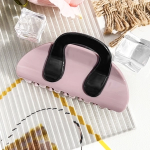 Close-up of pink and black contrast hair claw clip on frosted glass with ice deco