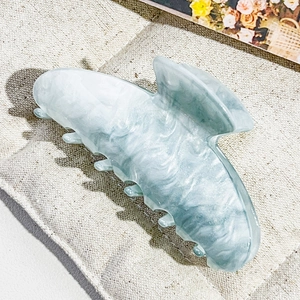 Close-up of a large blue marble acetate butterfly hair claw with smooth polished teeth
