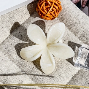 Dettaglio del fermaglio per capelli a fiori bianchi con finitura perlata lucida