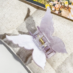 Detail of lavender butterfly hair claw with marble texture and golden spring mechanism