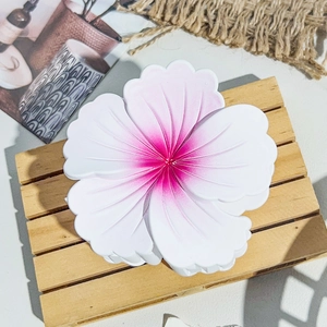 Gros plan sur la pince à cheveux fleur blanche avec dégradé rose sur bois naturel