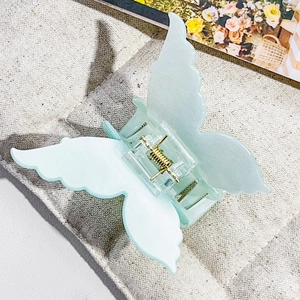 Detail of mint green butterfly hair claw clip with semi-transparent acrylic texture
