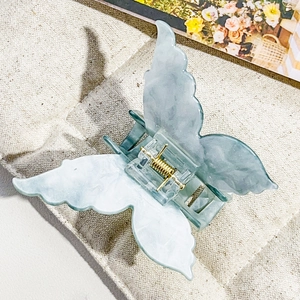 Detailed macro view of a 3D butterfly hair claw clip with blue marble texture