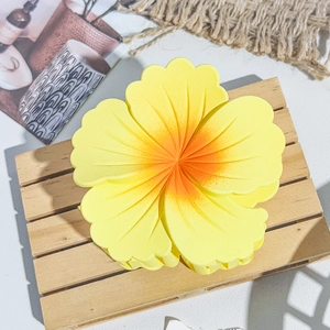 Détail d'une pince à cheveux fleur jaune mate avec dégradé orange sur support bois